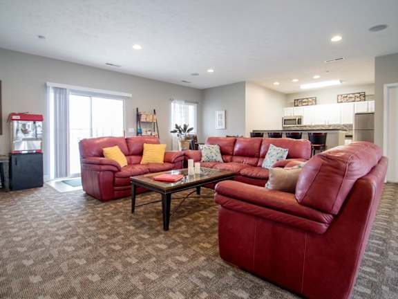 A living room with red couches and a coffee table.