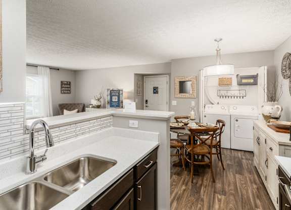 A kitchen with a table and chairs in the middle of it.
