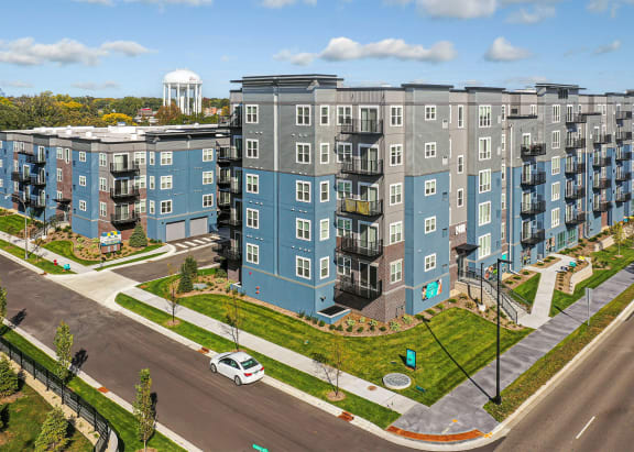 an aerial view of an apartment building with a parking lot and a street