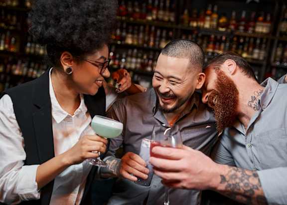 Friends Smiling while Having Drinks Together