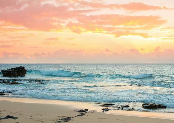 A serene beach scene with waves gently crashing onto the shore.