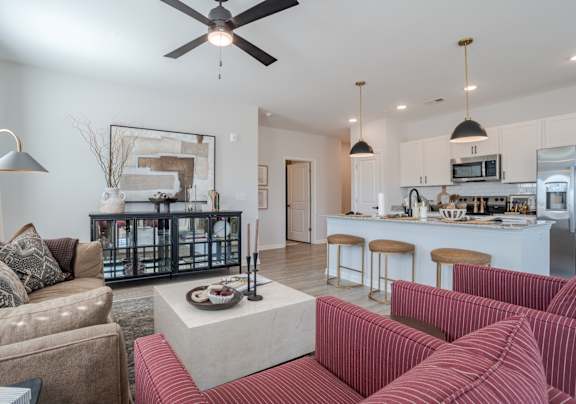 A living room with a red couch and a ceiling fan.