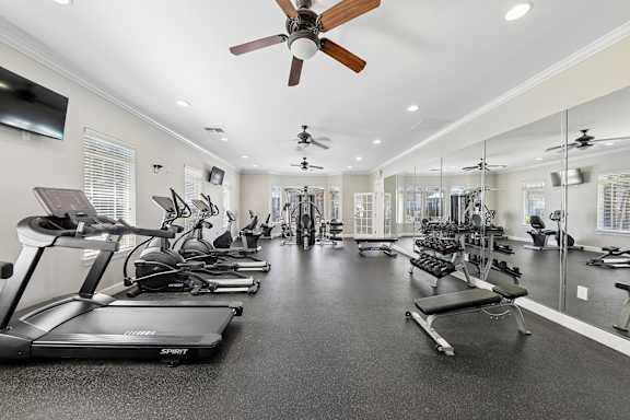 A spacious gym with treadmills, exercise bikes, and other equipment.