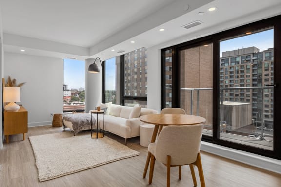 a living room with large windows and a couch and a table