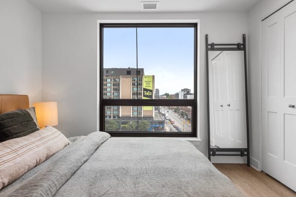 a bedroom with a large window and a bed