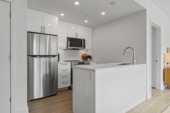 a kitchen with white cabinets and a stainless steel refrigerator
