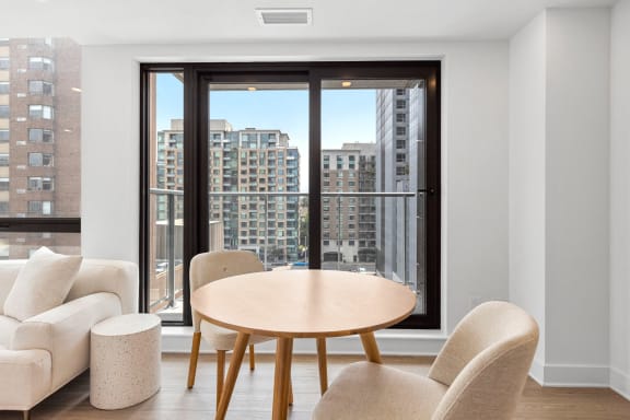 a living room with a table and chairs and a balcony