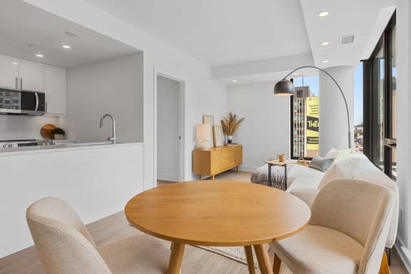 a living room and dining room with a table and chairs