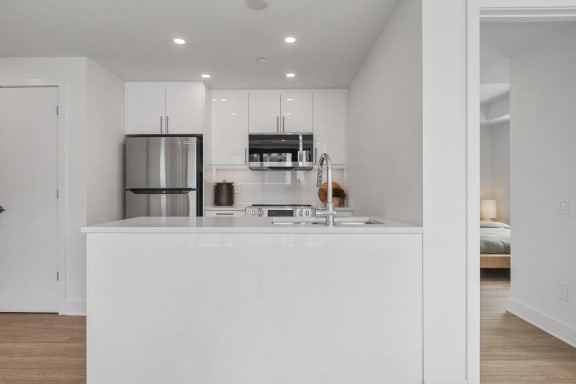 a kitchen with a white counter top and a refrigerator