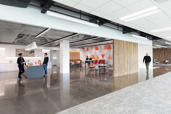 A modern office space with people walking and talking.