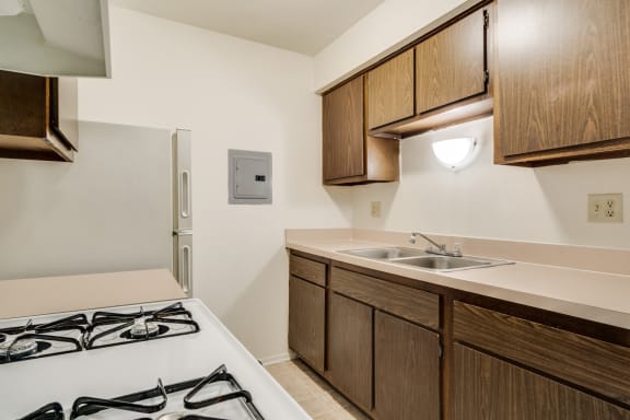 a kitchen with a stove and sink and a refrigerator at Rivers Edge Apartments in Waterford Twp, MI 48327