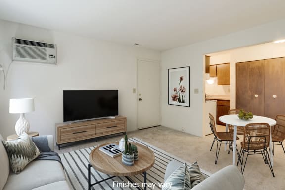 a living room with a couch and a table and a television at Rivers Edge Apartments in Waterford Twp, MI 48327