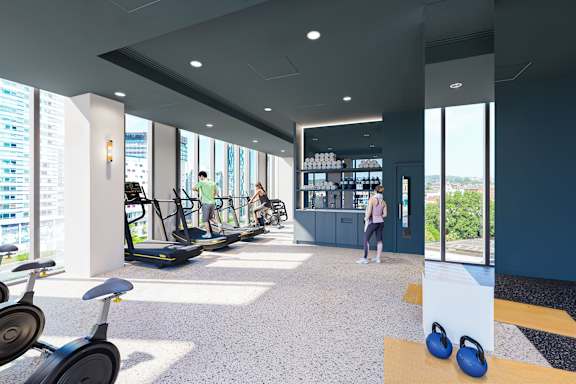 A gym with exercise equipment and a woman working out.