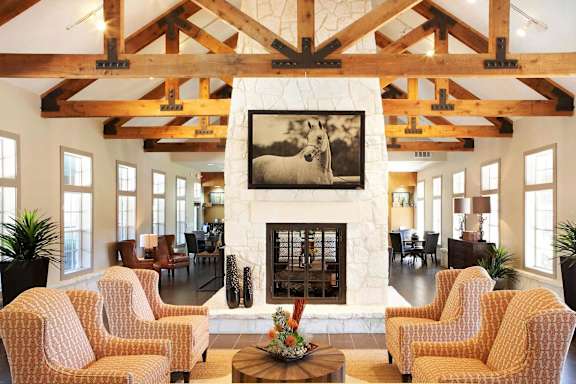 A living room with a fireplace and a painting of a dog.