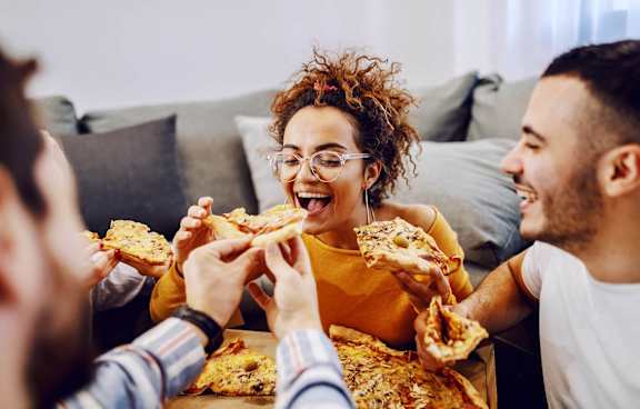 A group of people enjoying a pizza together.