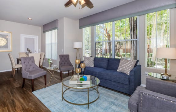 a living room with a blue couch and a glass coffee table