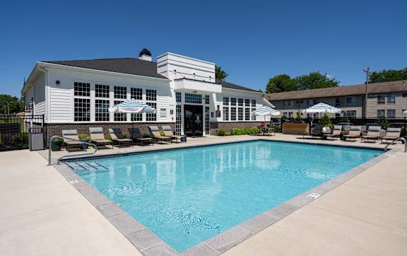 A large swimming pool in front of a white building.
