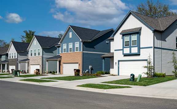 a row of houses with a sidewalk in front of them