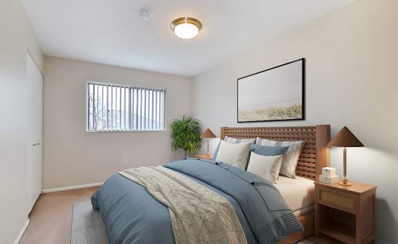 A bedroom with a bed, nightstand, and lamp.