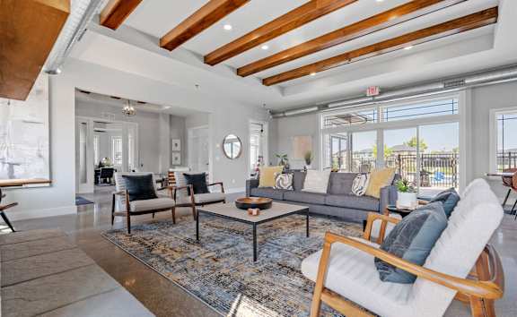 a living room with a couch and chairs and a large window