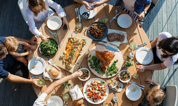 a group of people sitting around a table eating food