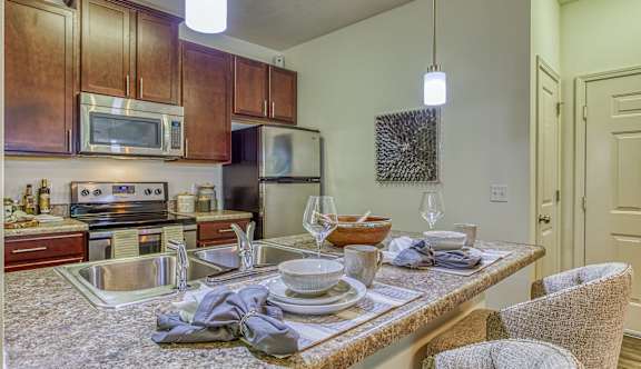 A kitchen with a table set for two.