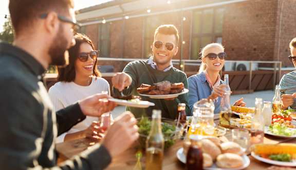 A group of people enjoying a meal together at an outdoor table.
