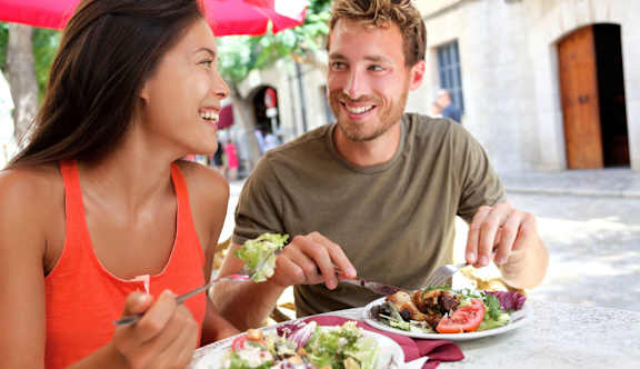 A man and a woman are eating salad outdoors at Fountains of Largo in Largo, FL at Fountains of Largo in Largo, FL