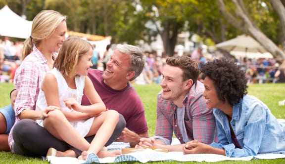 a group of people sitting on a picnic blanket