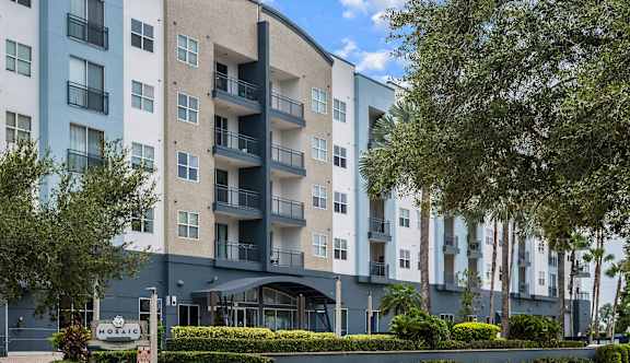 A modern apartment building with balconies and a sign that reads "HOSPITAL".
