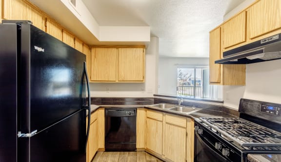 a kitchen with black appliances and wooden cabinets