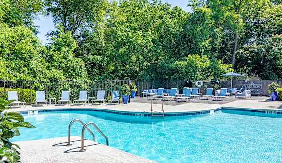 a swimming pool with chaise lounge chairs   and trees