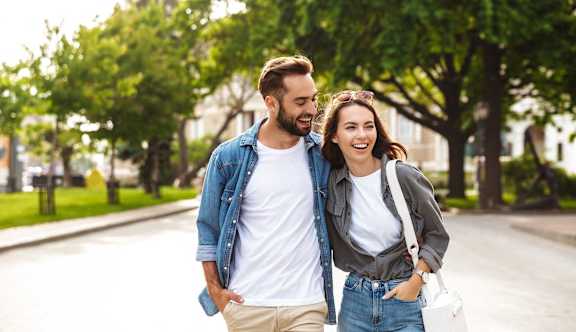 A man and a woman are walking together on a sunny day.
