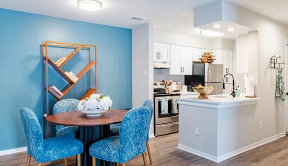 A living room with a blue couch and a television on a wooden cabinet.