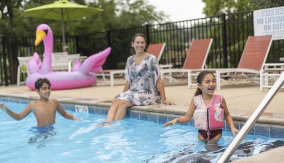 a mother and her two children play in a swimming pool at Sharon West, Charlotte, 28210