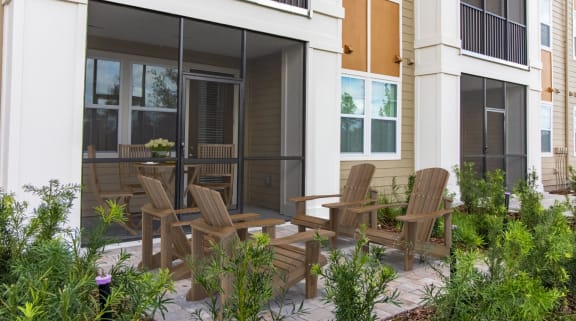 a patio with a table and chairs in front of a building