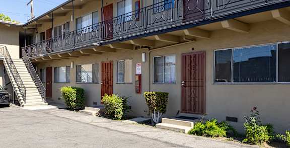A building with a balcony and a red door.