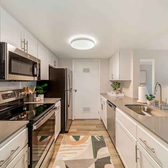 a kitchen with white cabinetry and stainless steel appliances at Citrine Hills, Ontario, CA, 91761