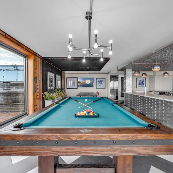 a large kitchen with a bar and a pool table