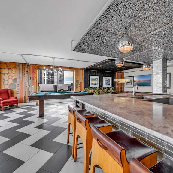 A black and white checkered floor in a room with a pool table.