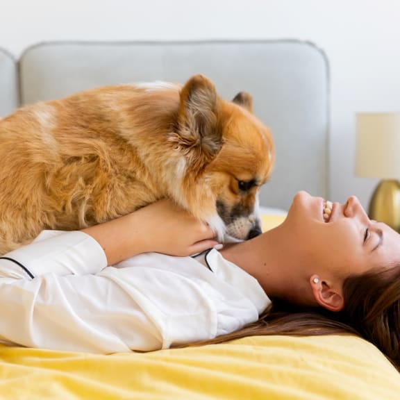 Woman Lying on Bed with Dog