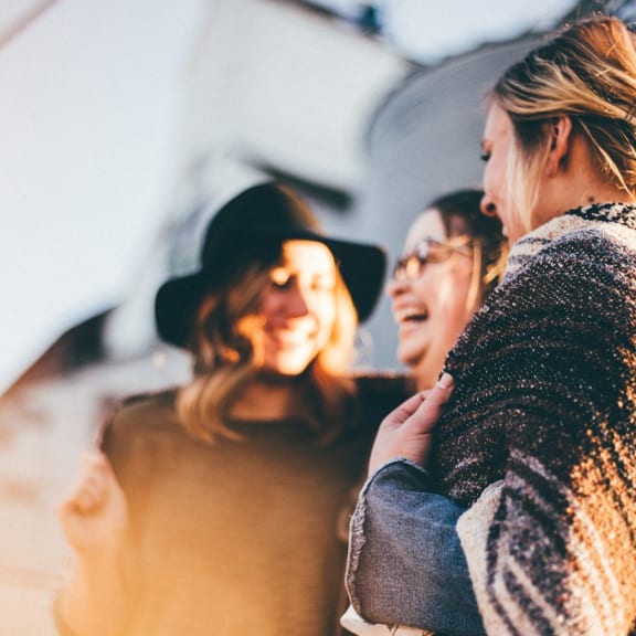 a group of women standing next to each other and laughing
