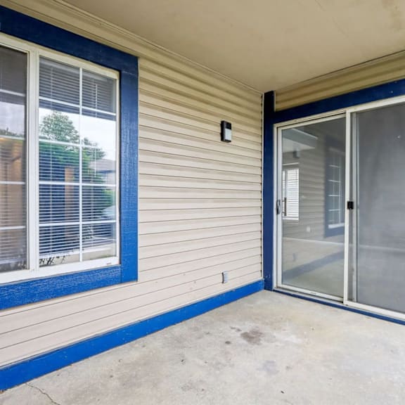 A blue and white house with a sliding glass door.