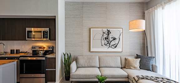 A modern living room with a grey sofa and a black coffee table.
