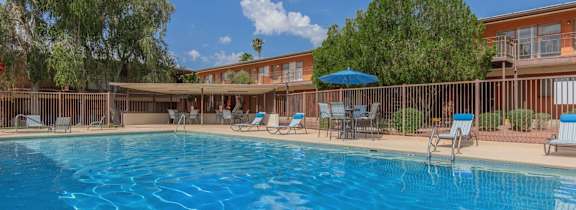 Country Club Apartments in Tucson, Arizona Exterior and Pool with Lounge Chairs and Covered Seating