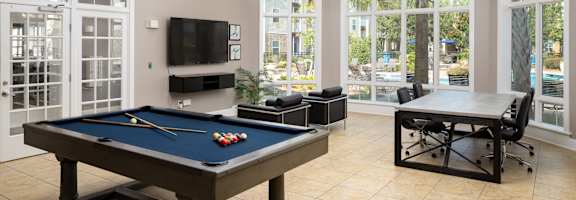 a games room with a pool table and a tv