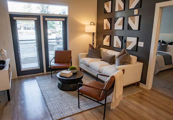 A living room with a white couch, a coffee table, and a lamp. at Sterling Nashville West Apartments, Nashville, Tennessee
