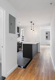 A modern kitchen with a refrigerator, microwave, oven, and sink.