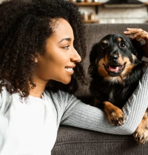 a woman sitting on a couch with her dog at Arlo Luxury homes Apartments, Little Rock, Arkansas