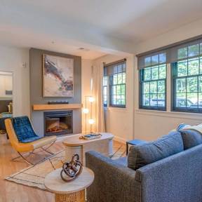 Modern living room with fireplace and large windows at The Overlook Apartments, Weymouth, MA 02188